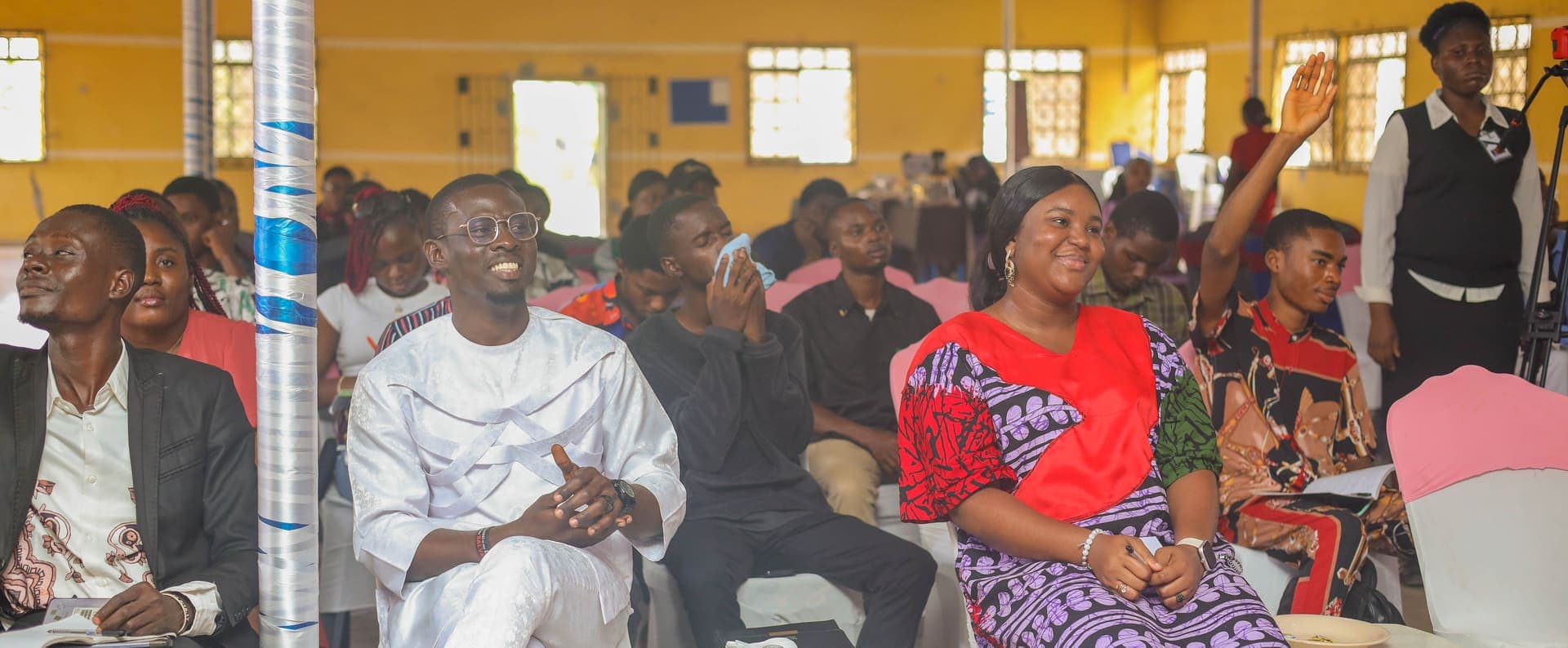 Young people in the audience at the 3F Conference, one hand raised with a question
