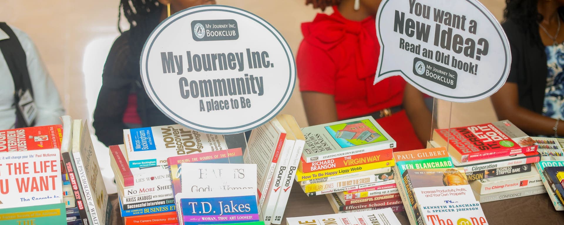 Stacks of leadership and personal development books on the Book Club table at the 3F Conference